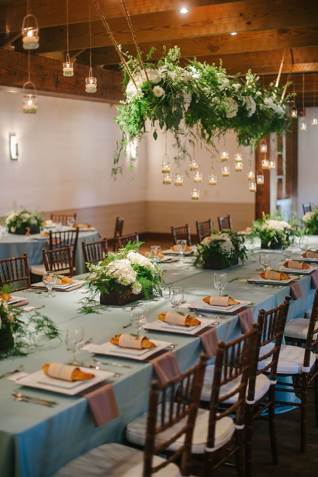 Hanging greenery and candle votives above a wedding reception table