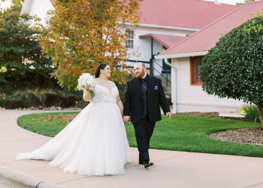 A bride and groom taking couples portraits outside of WinMock at Kinderton. It is just before sunset, the lighting being ideal for photos. 